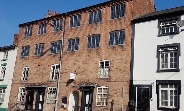 The building was originally six two-room cottages with 2 loom floors above. Each window had a loom. Now the cottages relate the woollen industry story